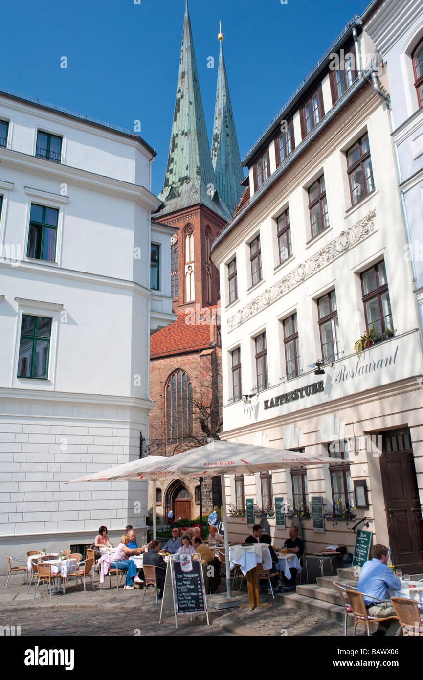 Cafe et de vieux bâtiments avec l'église Nikolaikirche dans historique de Nikolaiviertel de Berlin Banque D'Images