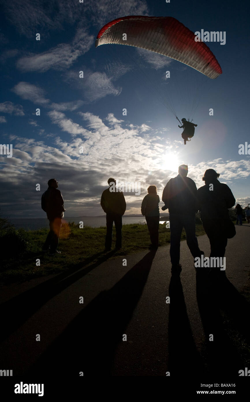 Un pilote parapente vole le long des falaises côtières Dallas Road à Victoria, BC, Canada. Banque D'Images