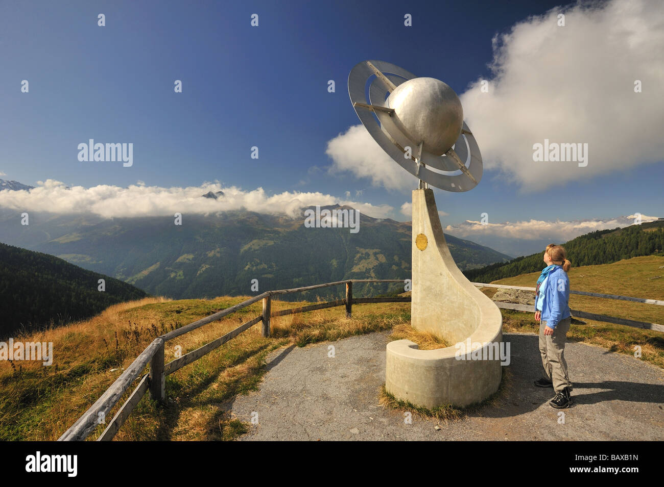 Une femme hiker admire une sculpture représentant les planètes Saturne le sentier (Sentier des planetes) dans les Alpes suisses. Banque D'Images