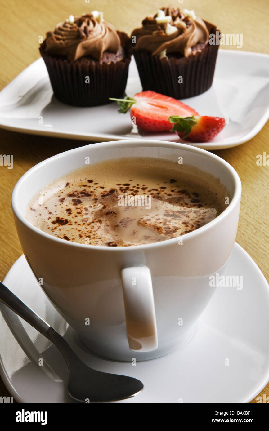Une tasse de café latte et petits gâteaux au chocolat avec des fraises. Banque D'Images