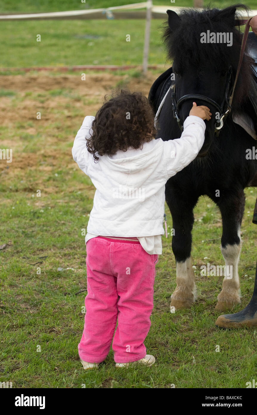 Kid est peting le poney Banque D'Images