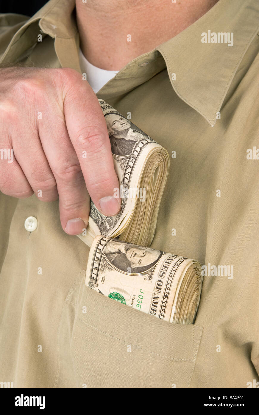 Un homme met liasses de billets dans sa poche de chemise Photo Stock - Alamy