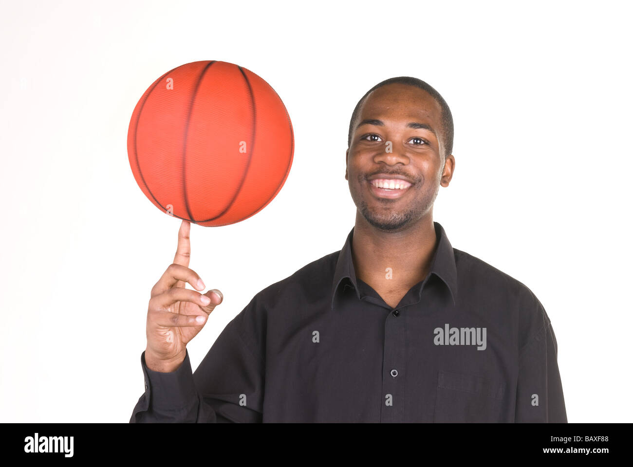 Un African American man tourne sur son doigt un terrain de basket-ball Banque D'Images
