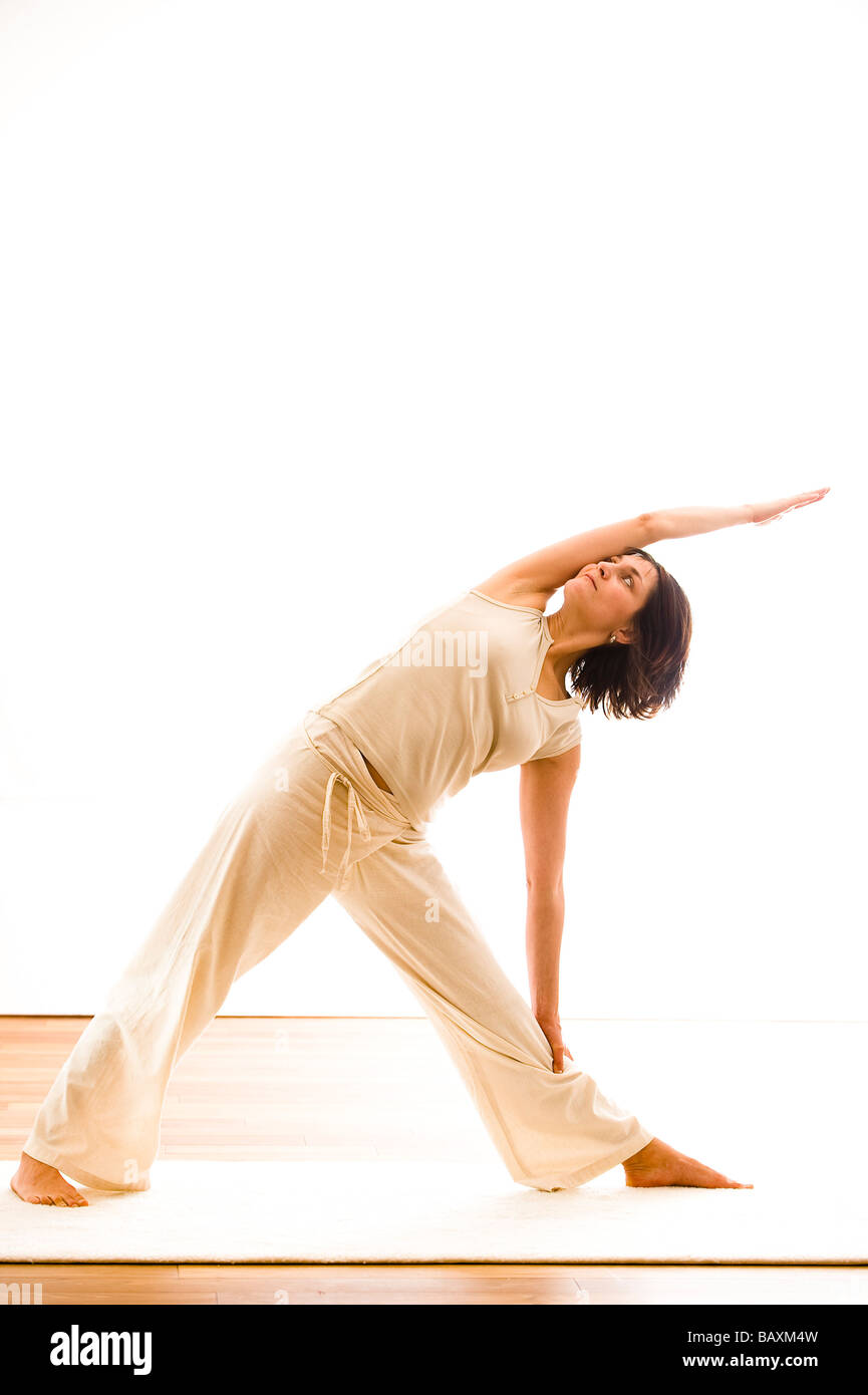 Mid adult woman practicing yoga (Trikonasana, Triangle), un studio de yoga à Linz, Autriche Banque D'Images