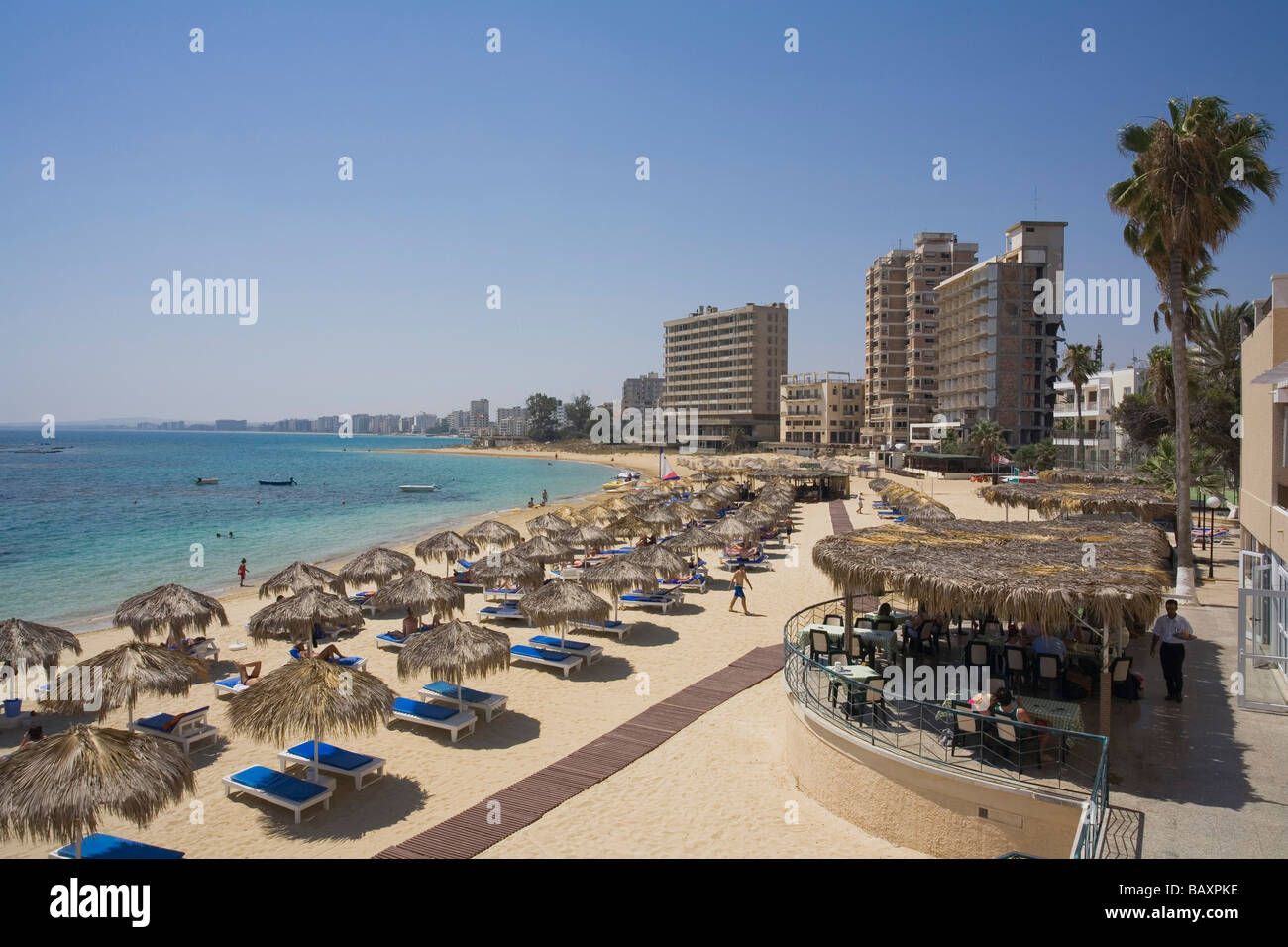 Terrasse de biffer Hôtel Palm Beach, plage de Varosha, avec les ruines de l'hôtel abandonné en arrière-plan, Famagusta, Gazimagusa, Chypre Banque D'Images