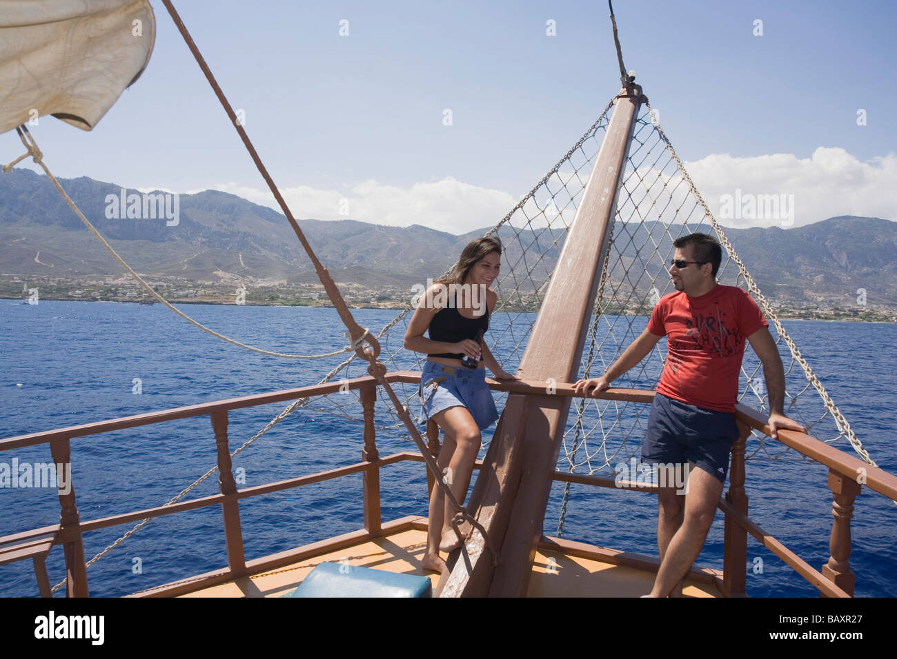 Un couple debout à la proue d'un navire, bateau pirate Neptun, par Kaleidoskop Turizm, et la côte, Kyrenia, Girne, Chypre Banque D'Images