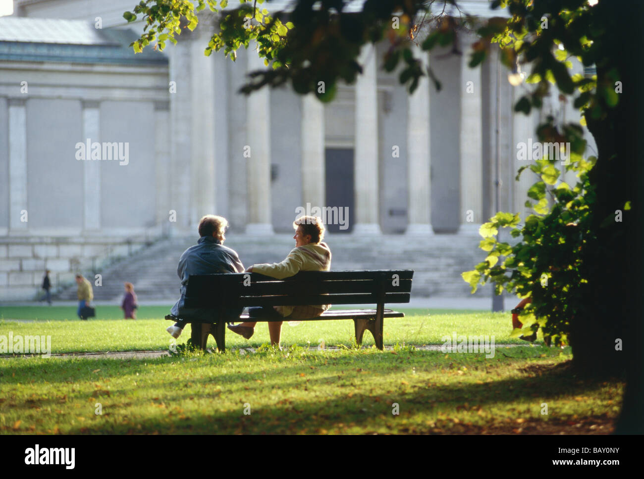 Couple assis sur un banc à Koenigsplatz, Munich, Bavière, Allemagne Banque D'Images