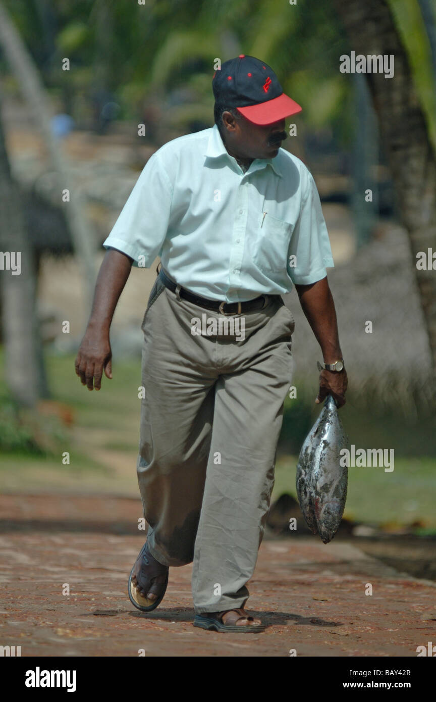 L'homme indien juste après avoir acheté un poisson frais à Varkala beach. Munnar, Kerala, Inde. Aucun communiqué de presse disponible. Banque D'Images