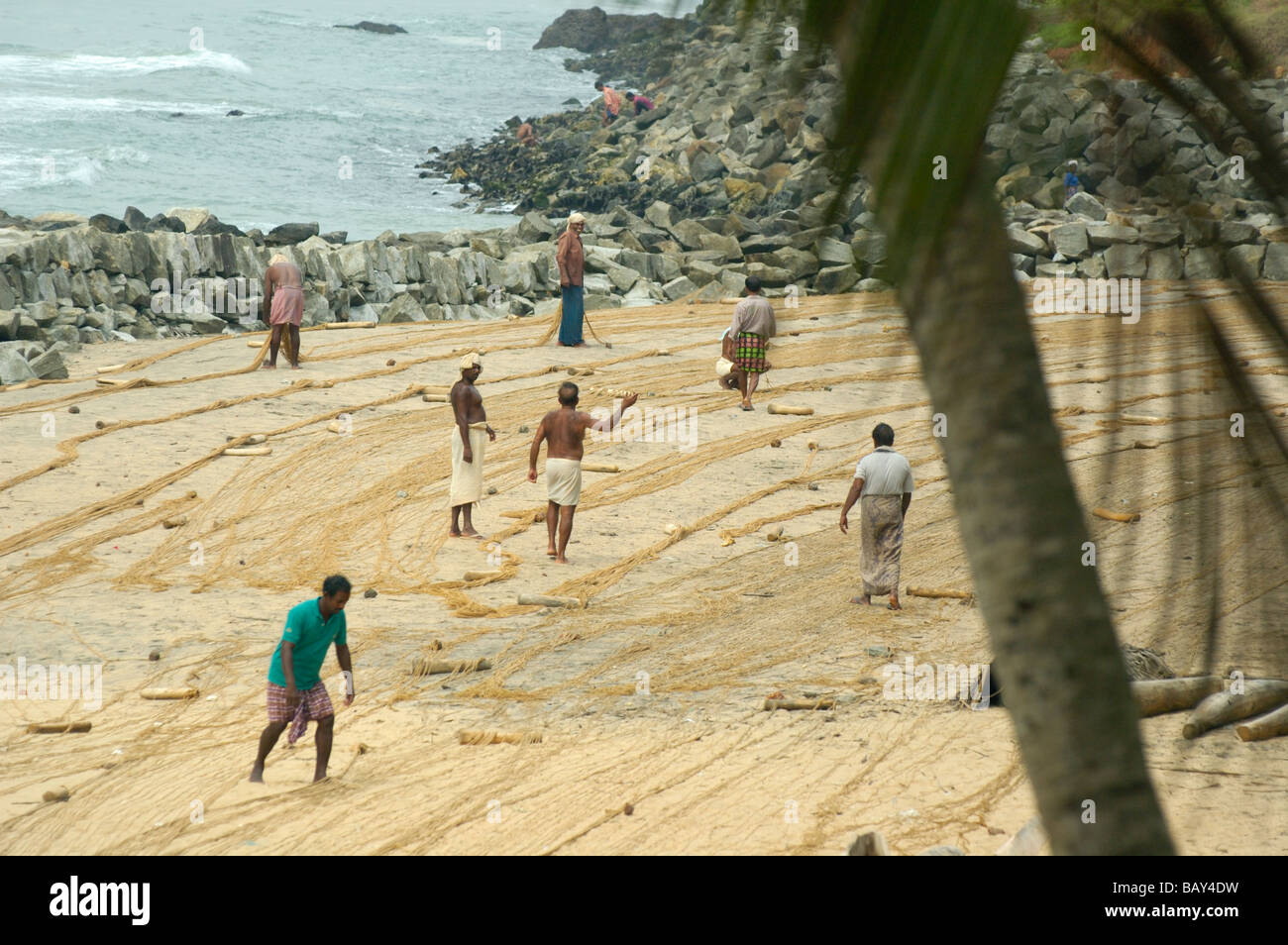 L'Inde, le Kerala, Varkala Beach. Les pêcheurs indiens préparent leurs filets de pêche à Varkala beach. Aucun communiqué de presse disponible. Banque D'Images