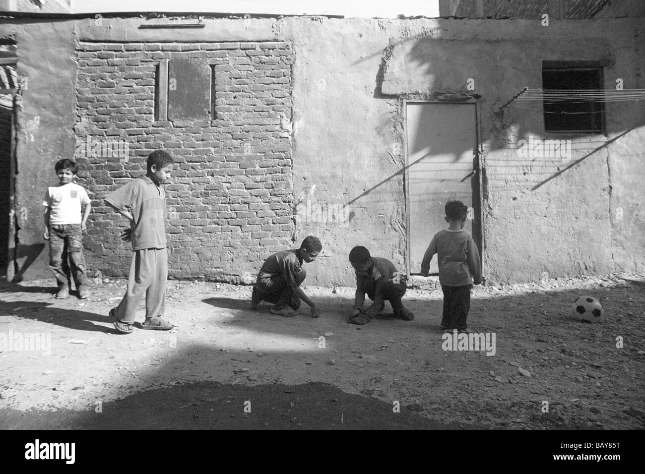 Garçons jouant aux billes dans le quartier de Taba, à l'extérieur de wa Noos Medinet Nasr. Banque D'Images