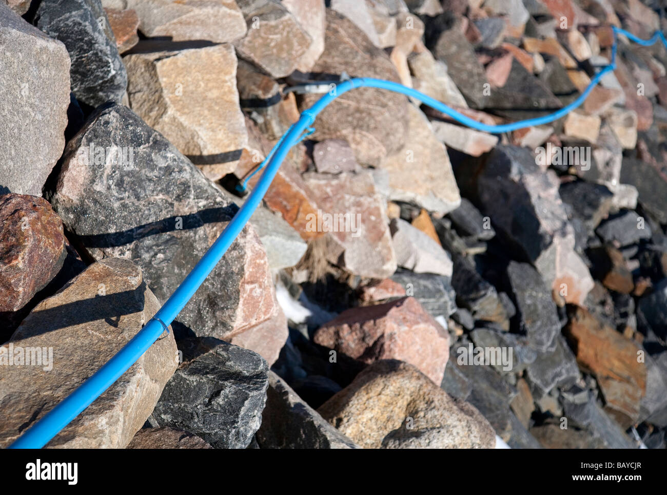 Monté en surface, le câble bleu sur terrain rocailleux Banque D'Images