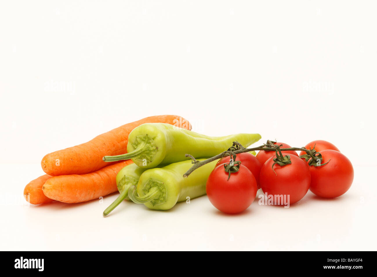 Diverses matières et des légumes frais (vert paprica, tomates, carottes) isolées (découpe) sur fond blanc. Close up & personne. Banque D'Images