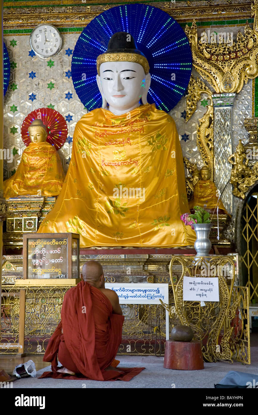 Le moine bouddhiste adorant Bouddha. Paya Shwedagon. Yangon. Myanmar Banque D'Images