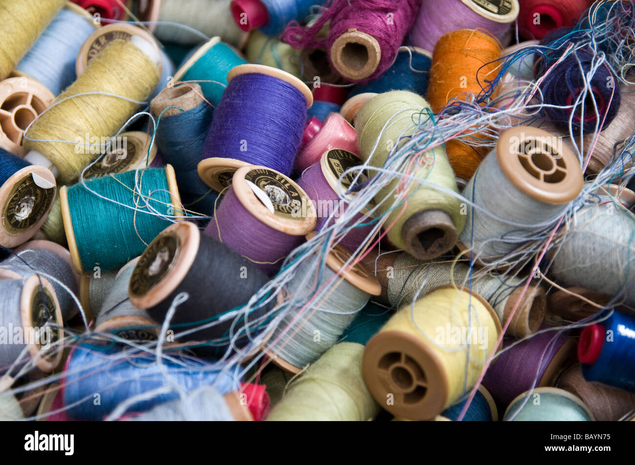 Bobines de fil de coton mélangé ensemble dans un box at a market stall dans la médina. Bleu, violet, blanc, jaune, mauve, rose Banque D'Images