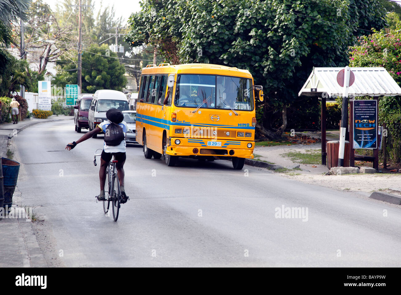 Scène de rue à la Barbade l'homme sur un vélo avec bus local en arrière-plan Banque D'Images