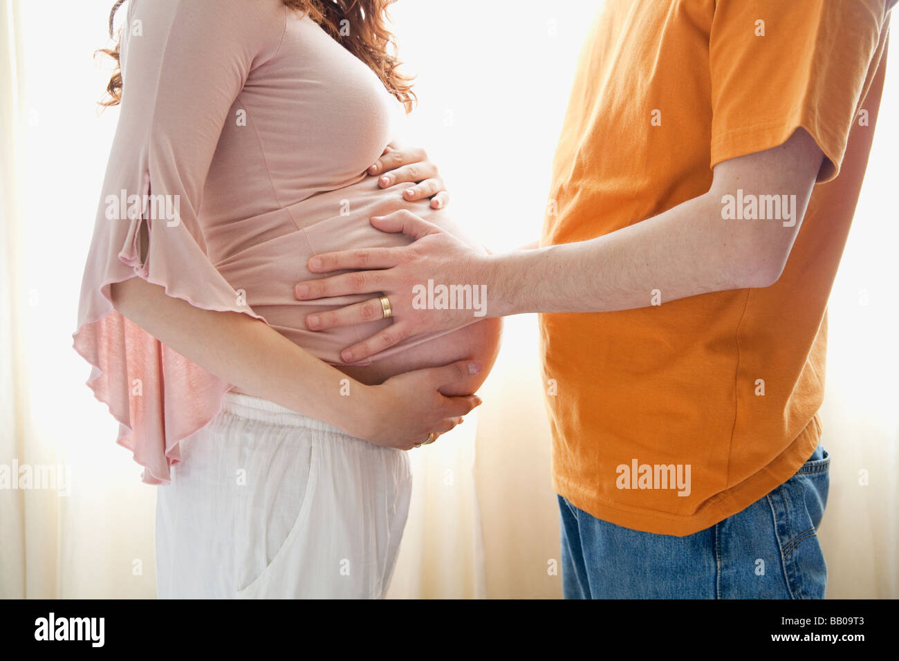 Man touching pregnant wife's estomac Banque D'Images