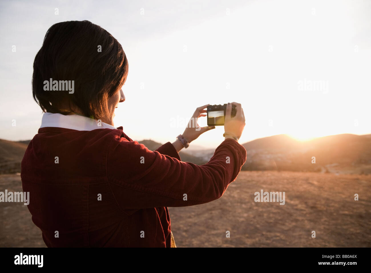 Hispanic woman photographier le coucher du soleil Banque D'Images