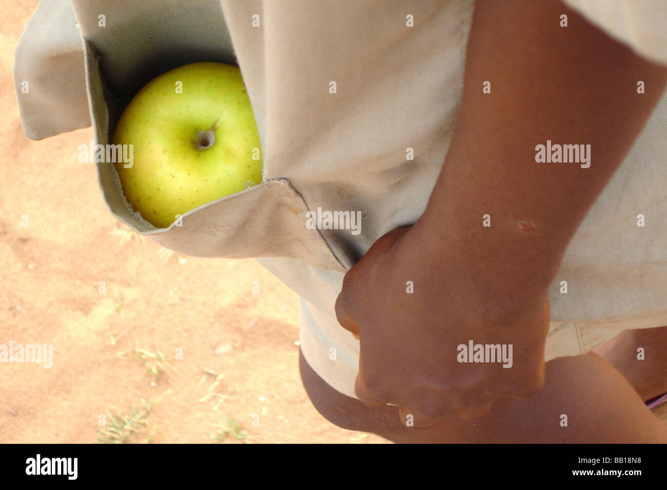 Bénin Porto Novo apple vert caché dans la poche d'un garçon vêtu d'un uniforme scolaire beige Banque D'Images