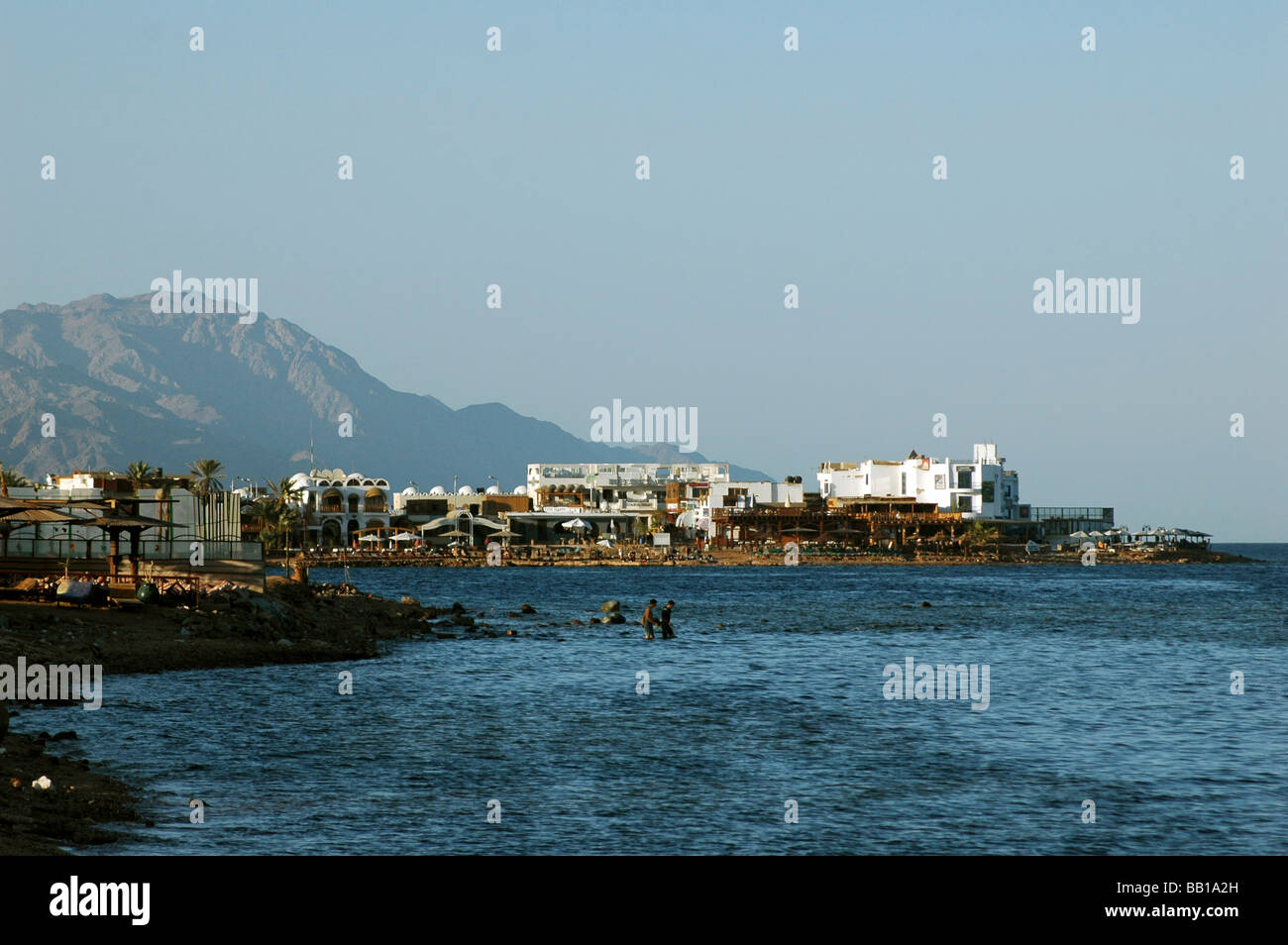 L'EGYPTE, Dahab. Maisons, et des palmiers d'une petite ville construite sur les bords de la mer Rouge, au pied d'une montagne rose (RF) Banque D'Images