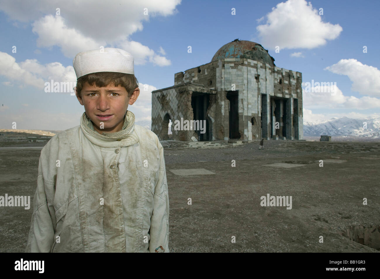 Jeune garçon en face de guerre déchirée National Monument, Kaboul, Afghanistan. Banque D'Images