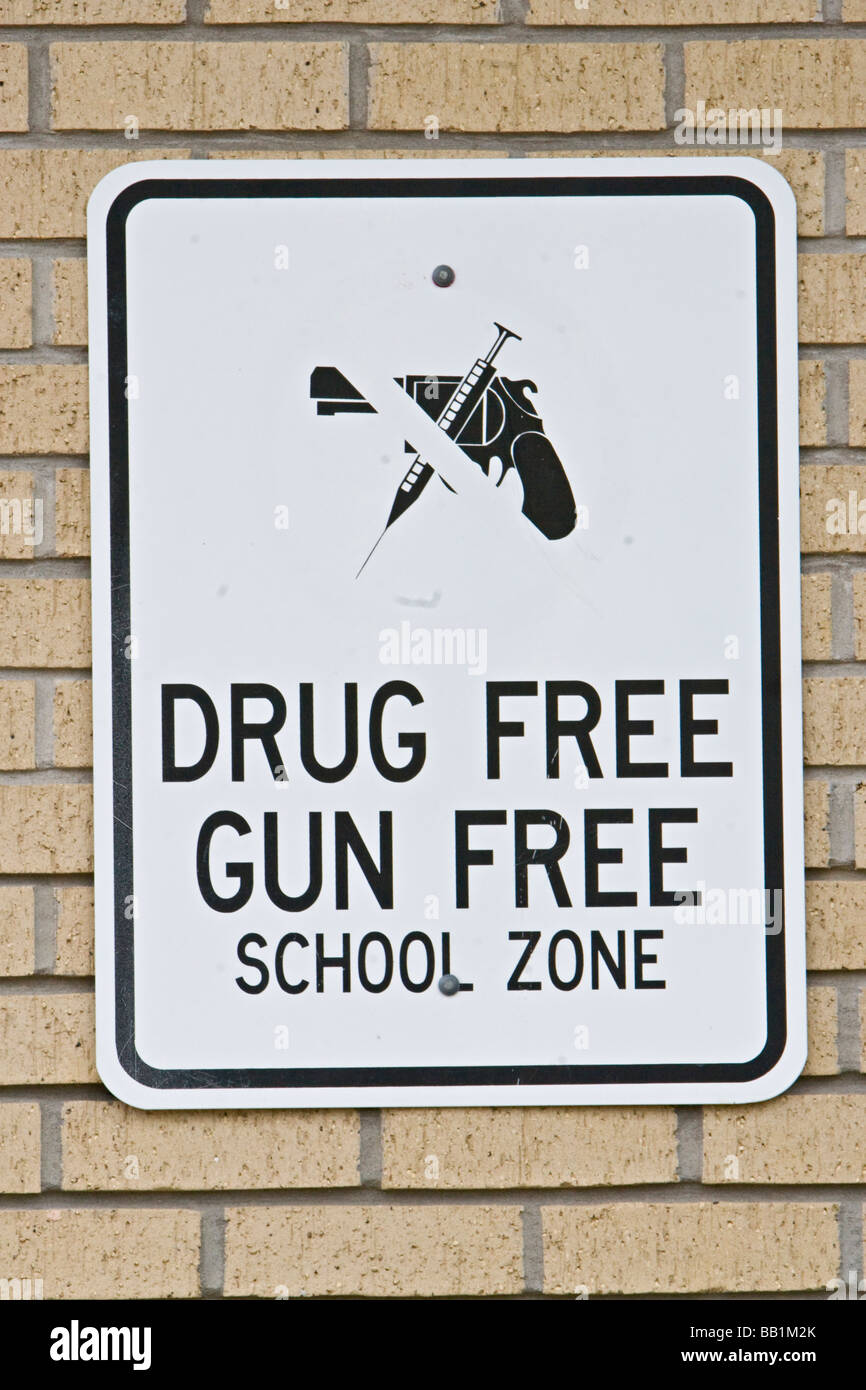 Gun free drug free zone scolaire sign posted on wall Banque D'Images