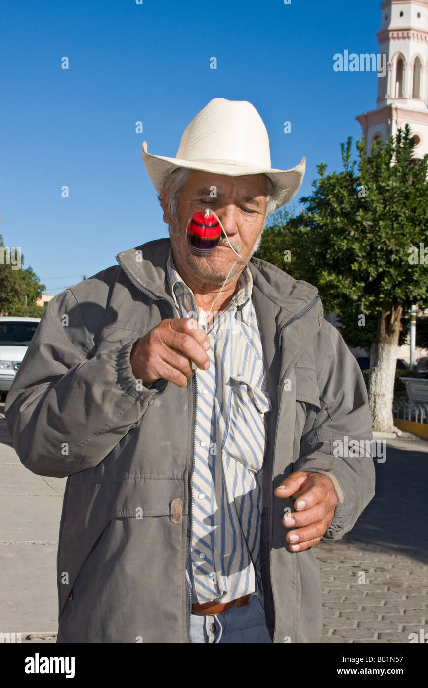 Homme de la région de El Fuerte, Mexique, joue avec un jouet de l'enfant appelé balero. Il y a une balle sur une corde attachée à un bâton. Banque D'Images