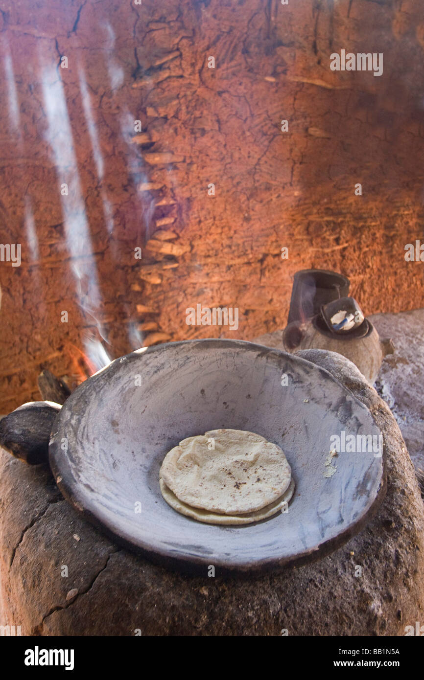 La lumière du soleil et la fumée avec tortilla de maïs la cuisson au wok casserole métal graissés avec de la moelle osseuse chez les village de Mayo, Capomos, Mexique Banque D'Images