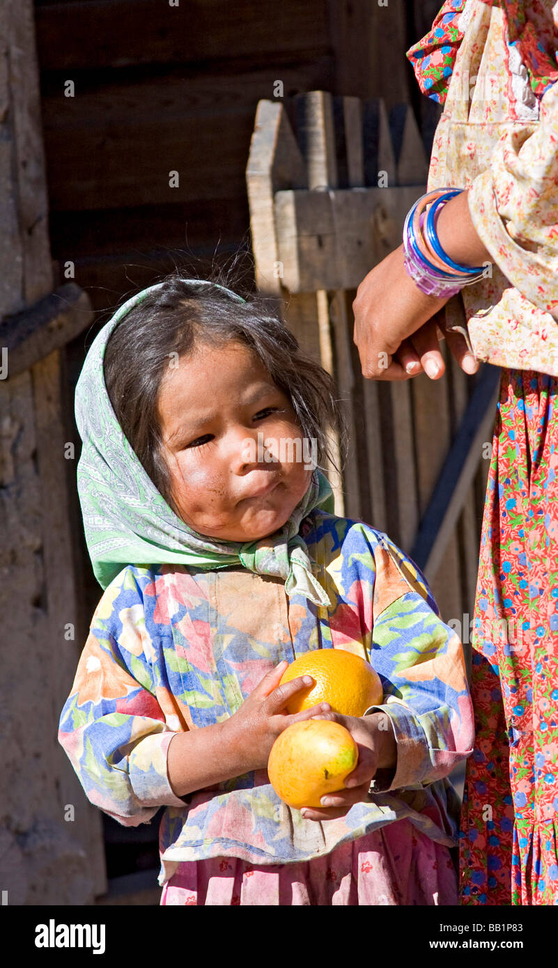 Young Girl holding kiosques de fruits avec sa mère par leur adobe et connectez-vous accueil dans le village de Tarahumara Copper Canyon Banque D'Images