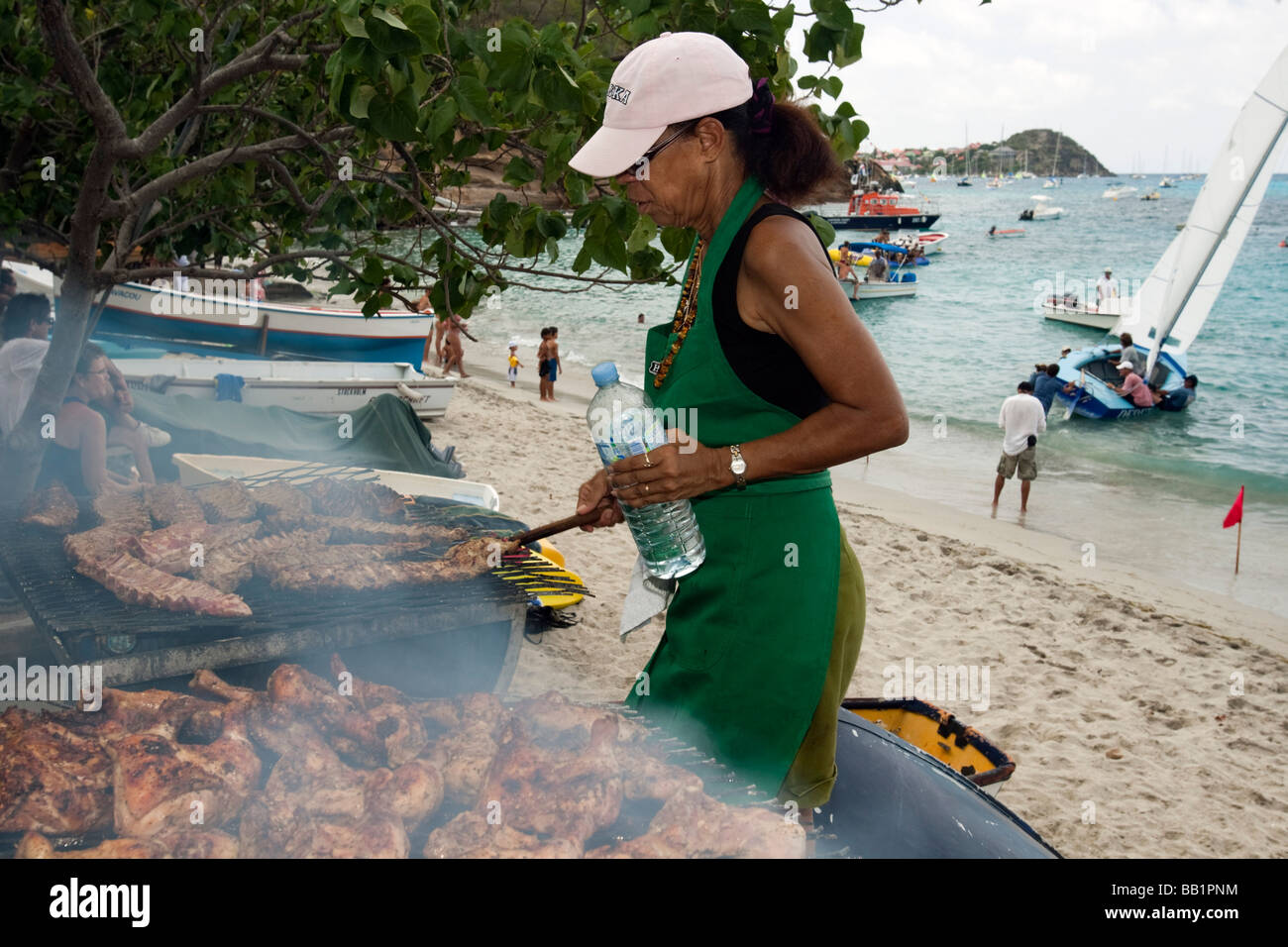 Femme prépare et côtes barbecue poulet Festival Saint Louis St Barth Corossol Banque D'Images