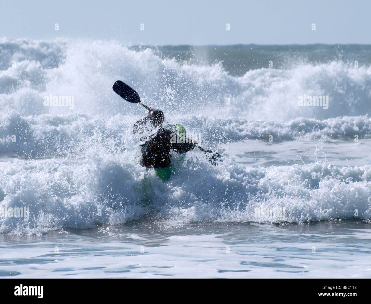 Kayakiste de mer luttant à travers les vagues Banque D'Images