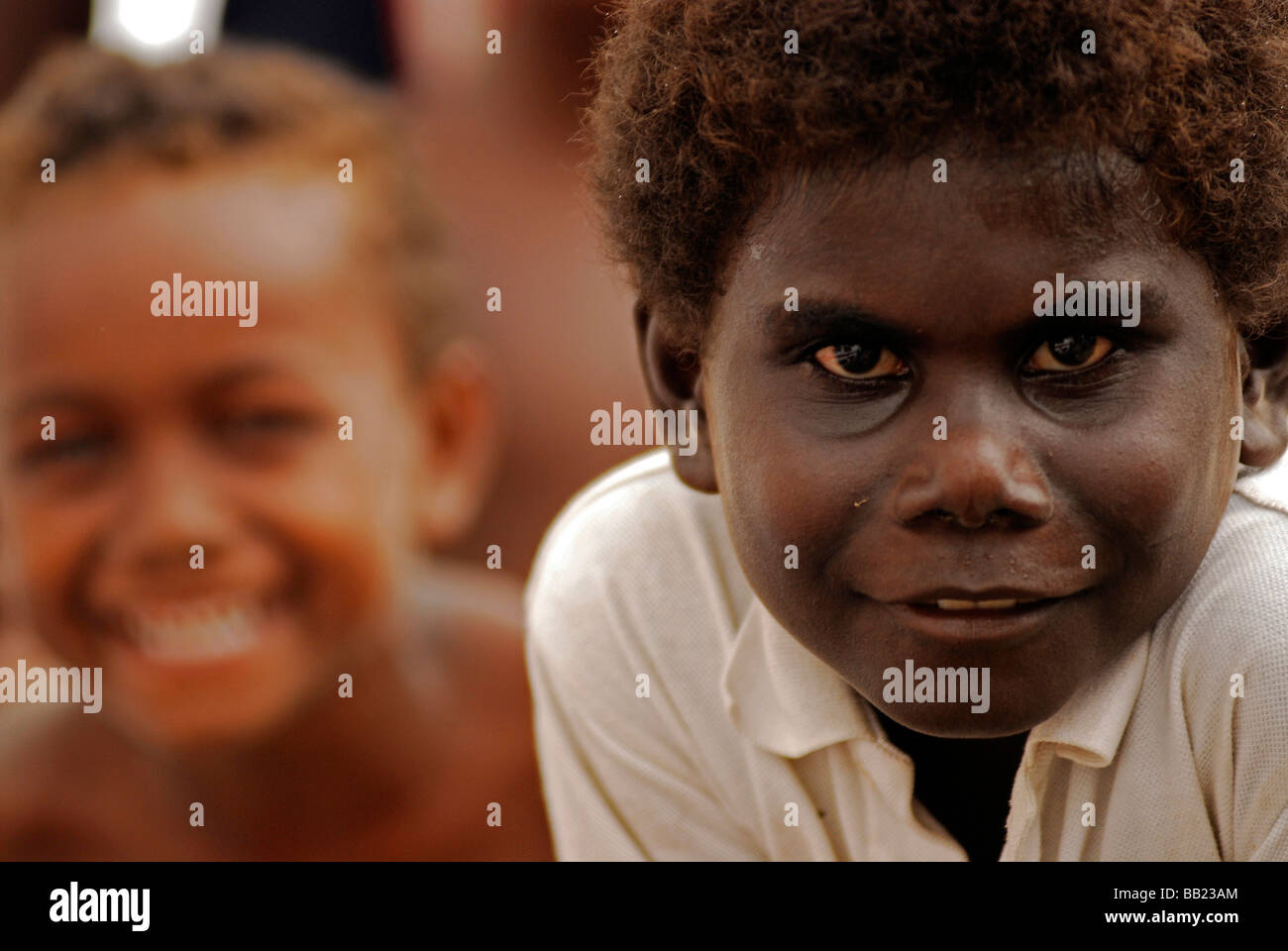 Îles Salomon. Portrait d'un garçon noir mélanésien avec de longs cheveux  crépus, un garçon à la peau brune sourit en arrière-plan Photo Stock - Alamy