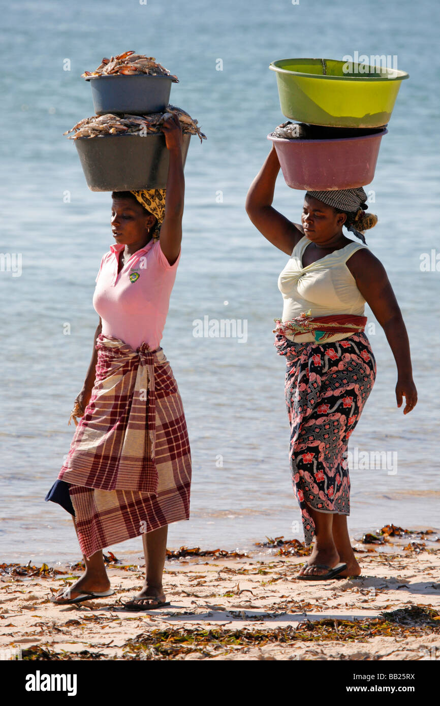 Deux femmes portant les captures le long de la plage de Vilanculos au Mozambique Banque D'Images
