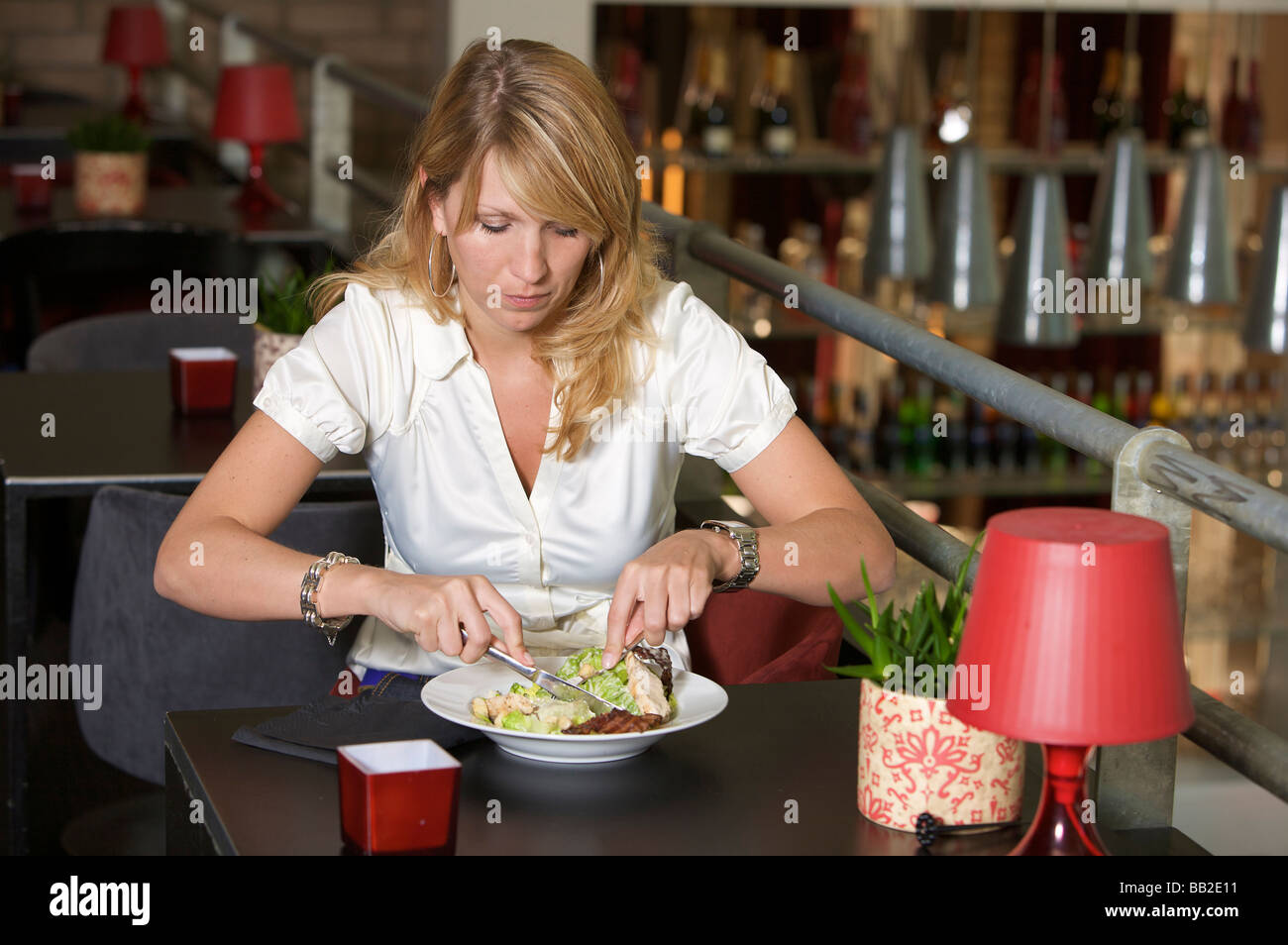 Jolie blonde businesswoman having un déjeuner sain dans un restaurant Banque D'Images