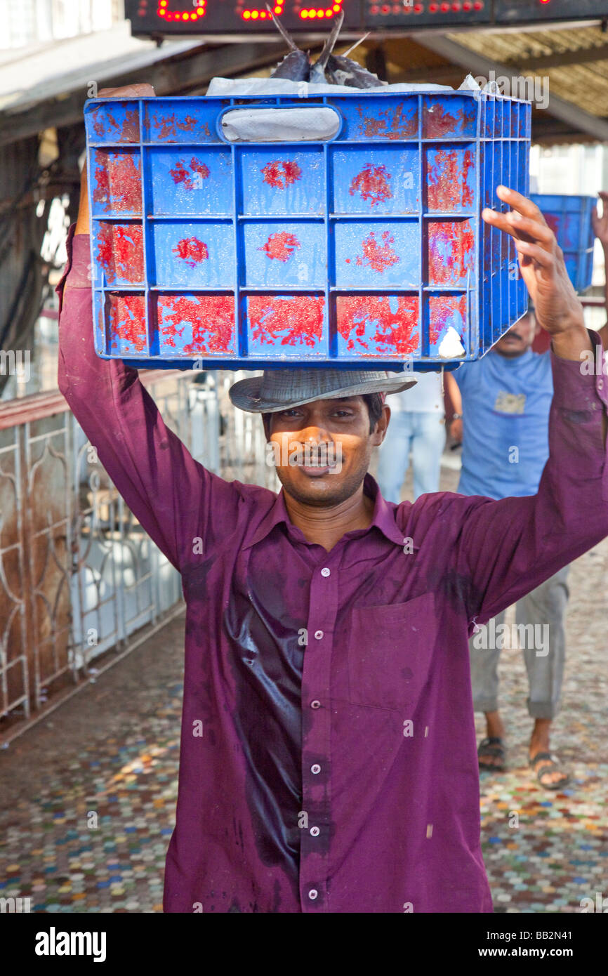 L'homme au Victoria Terminus transportant du poisson frais du marché sur la tête de Mumbai Inde Banque D'Images