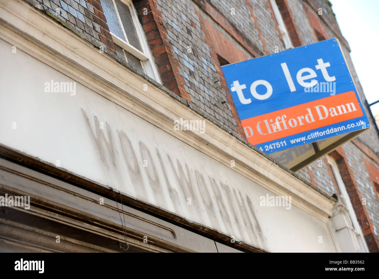Les lettres supprimées forment un vieux magasin Woolworths et un 'laisser' signe au-dessus d'un magasin vide de Lewes, East Sussex. Banque D'Images