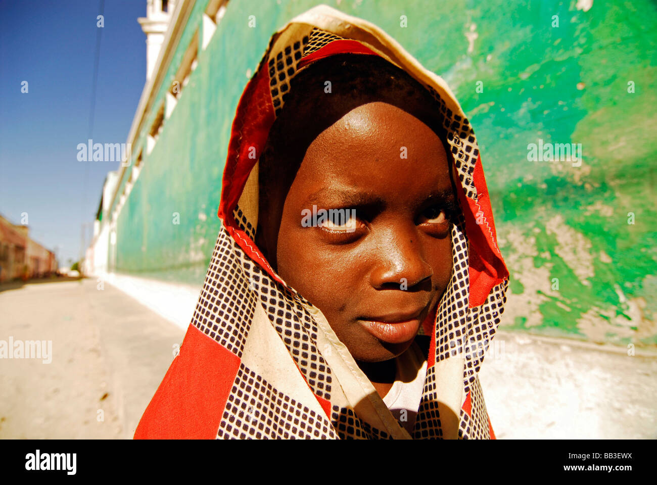Le MOZAMBIQUE, l'Ilha de Mozambique. Portrait d'une jeune fille africaine avec une longue rouge blanc et gris tissu couvrant la tête Banque D'Images