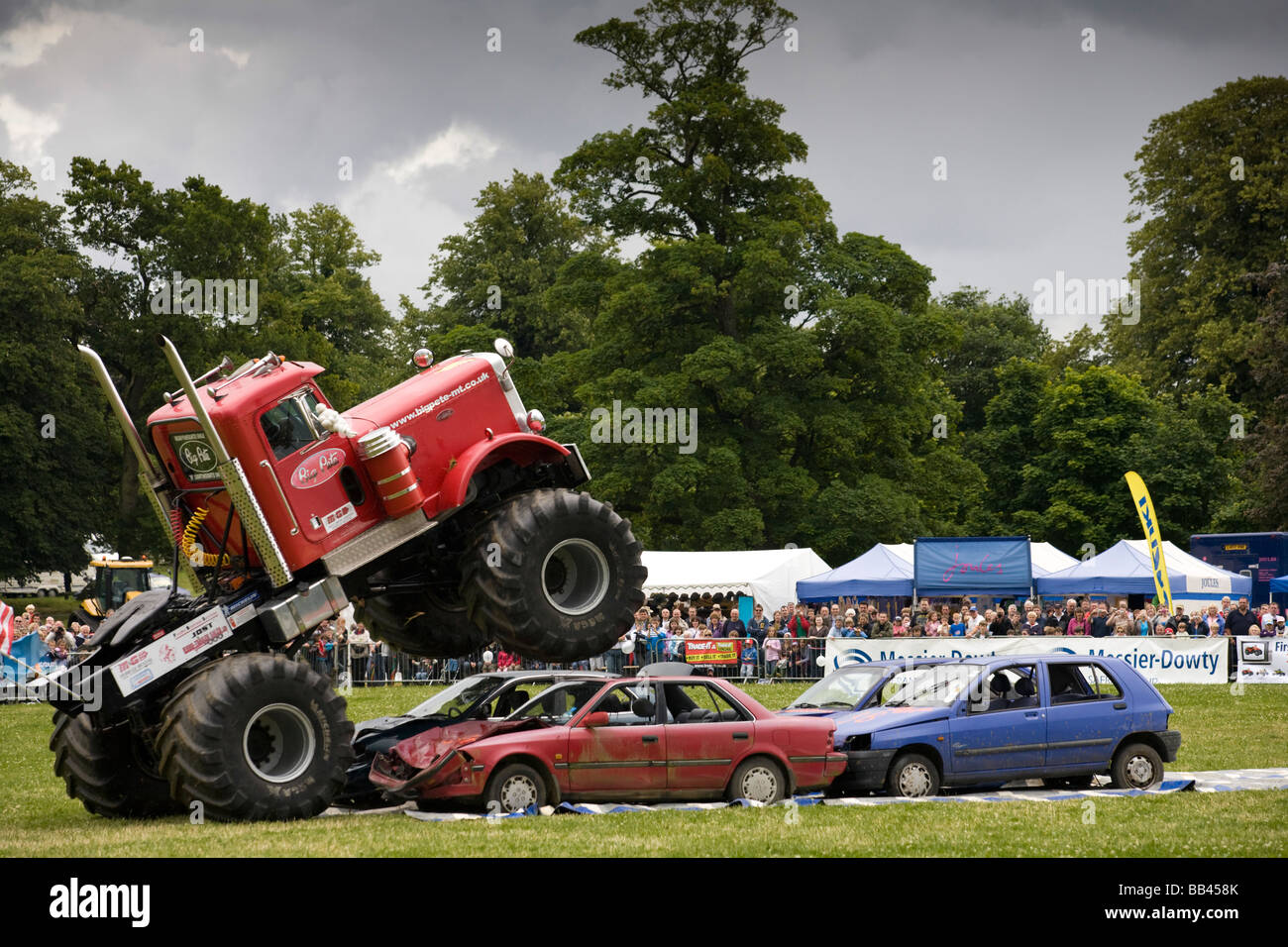 Monster trucks écrasement de vieilles voitures lors d'une foire agricole, Gloucestershire, Royaume-Uni Banque D'Images