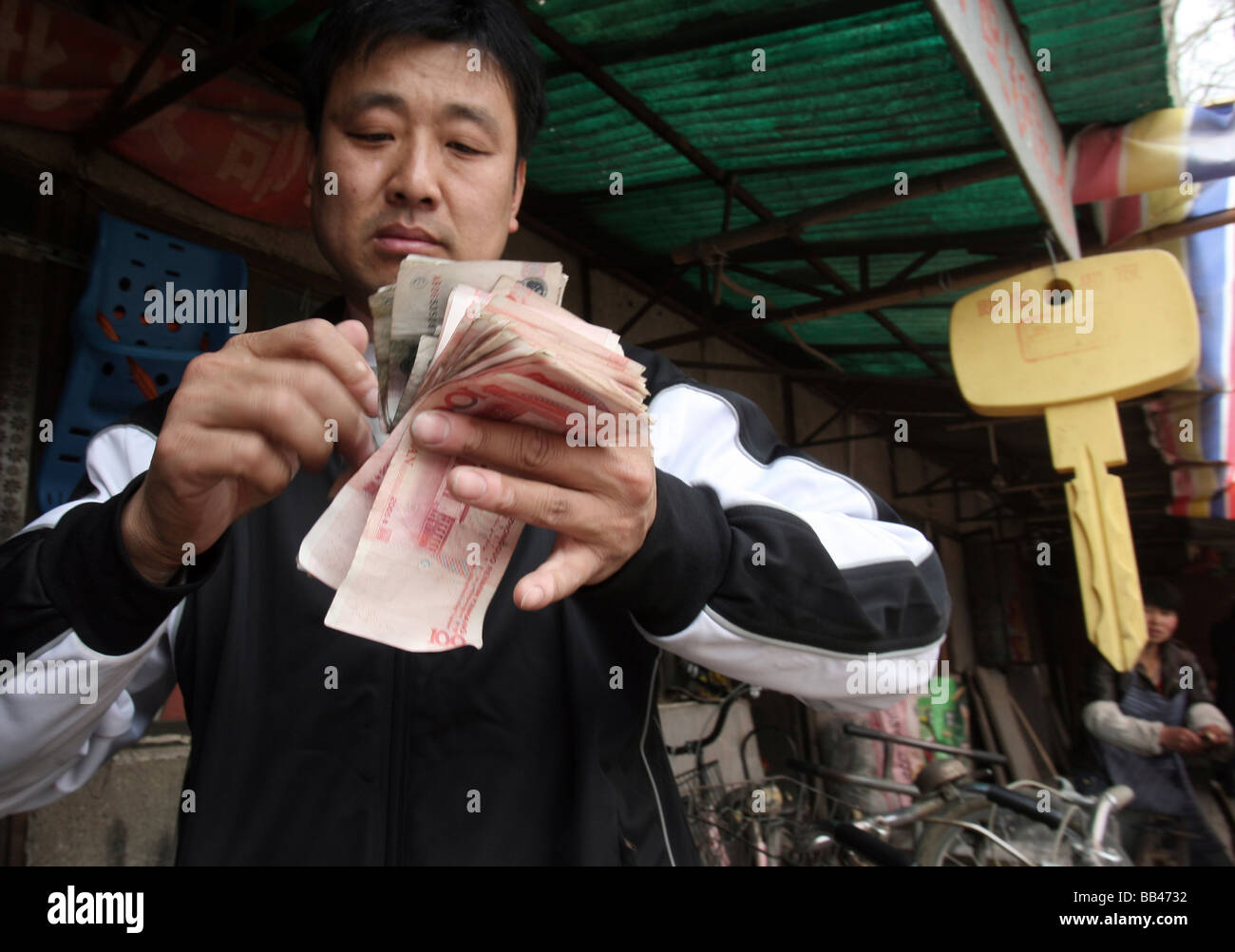 L'homme compte argent chinois dans la région de West 4th Ring North, Beijing, Chine. Banque D'Images