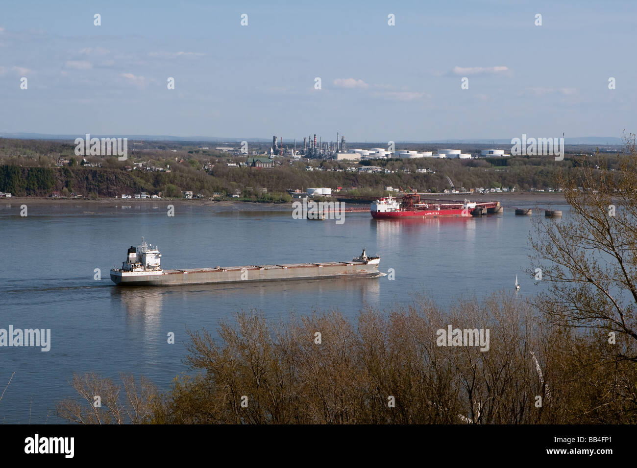 Un bateau naviguant sur le Saint-Laurent passe près d'un pétrolier à quai à la raffinerie Ultramar en face de la ville de Québec Banque D'Images