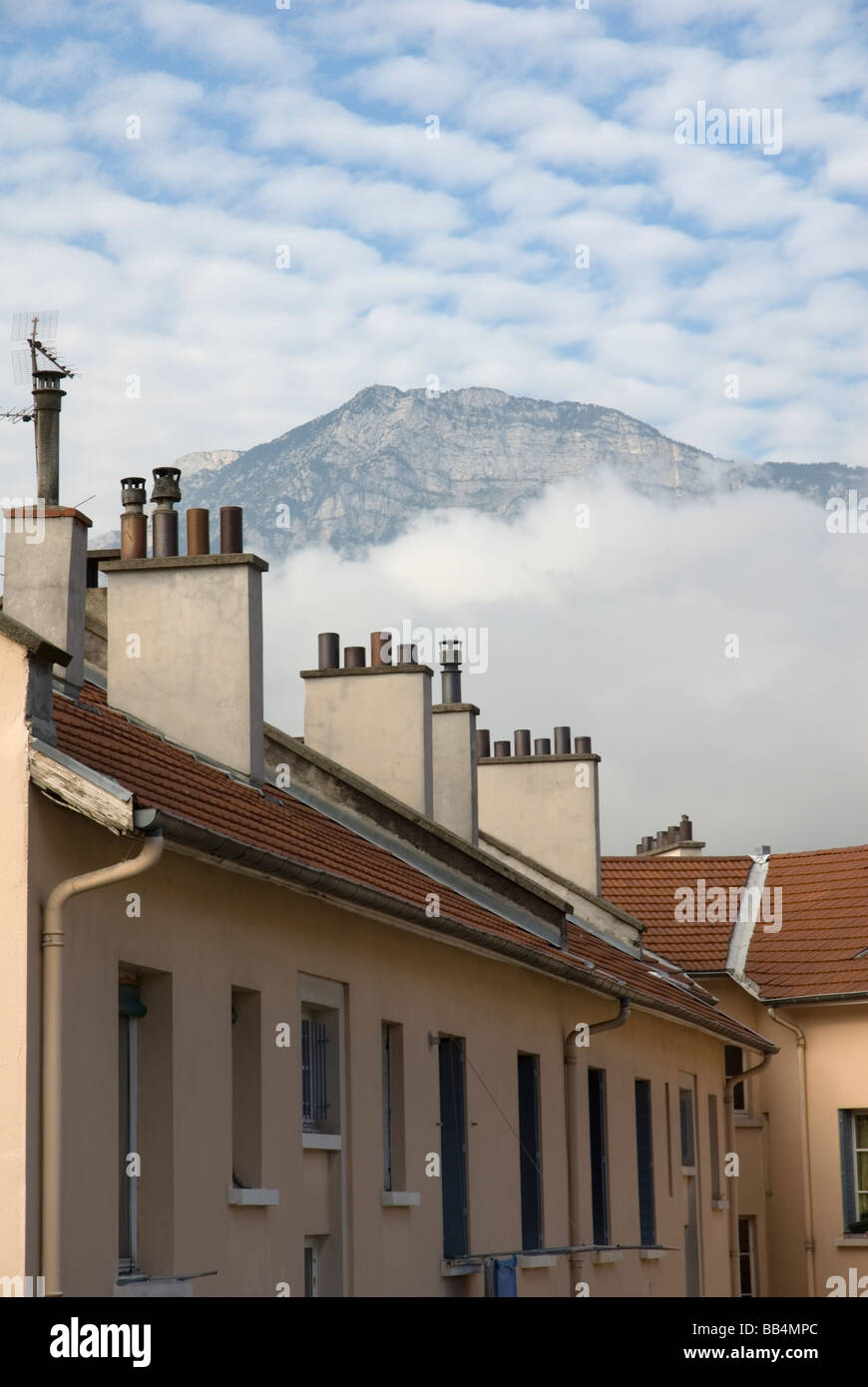 Vue sur les toits et cheminées avec des nuages et montagne en arrière-plan Grenoble,France,europe,EU Banque D'Images