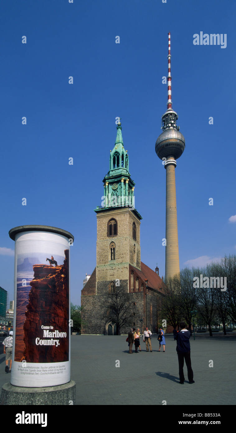 Eglise St Nicolas Saint-Nicolas et la tour de télévision symbole de l'ancien Berlin Ouest est communiste avec la publicité à Berlin Allemagne Banque D'Images