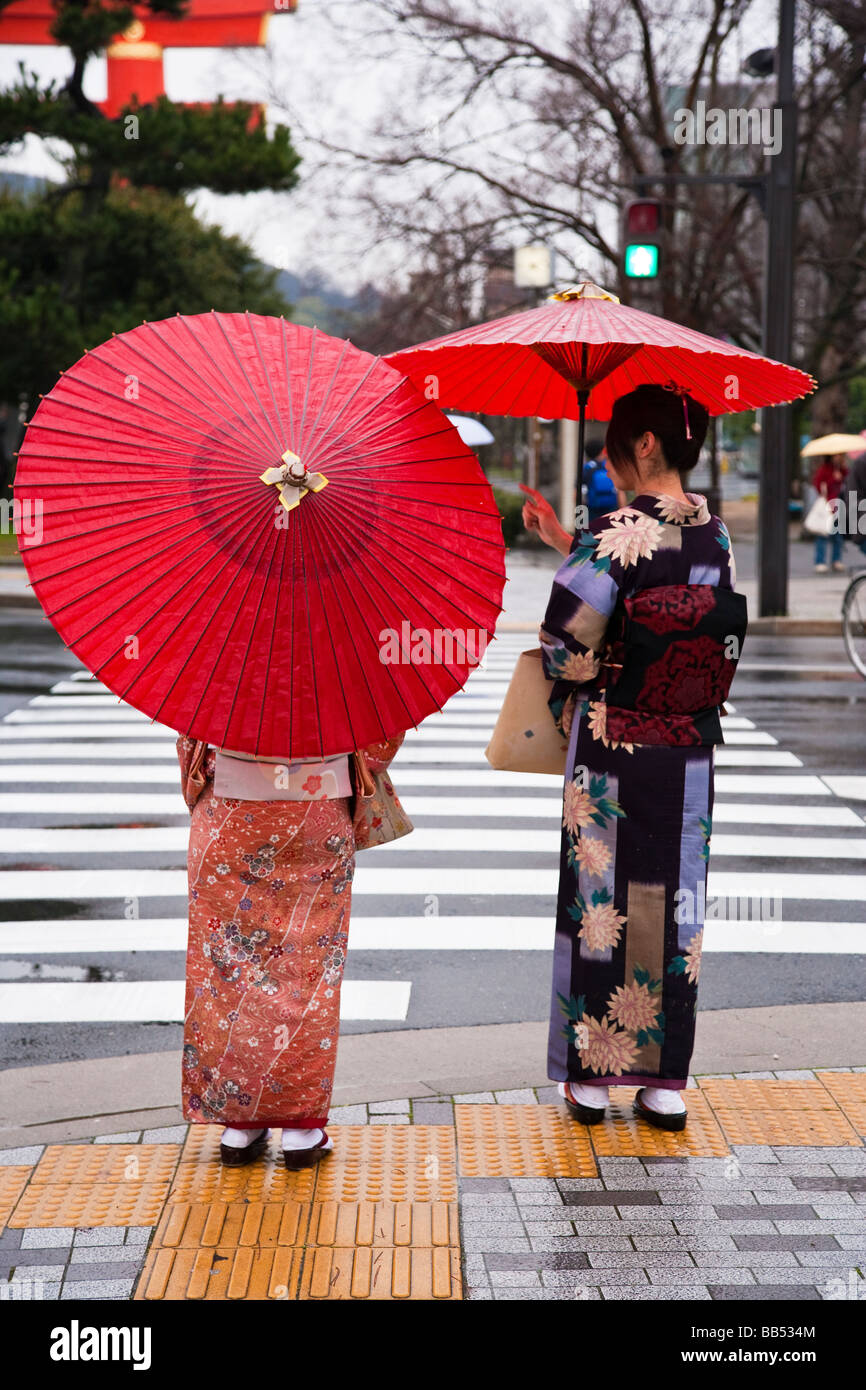 Portant des parapluies de kimonos au japon Banque de photographies et d