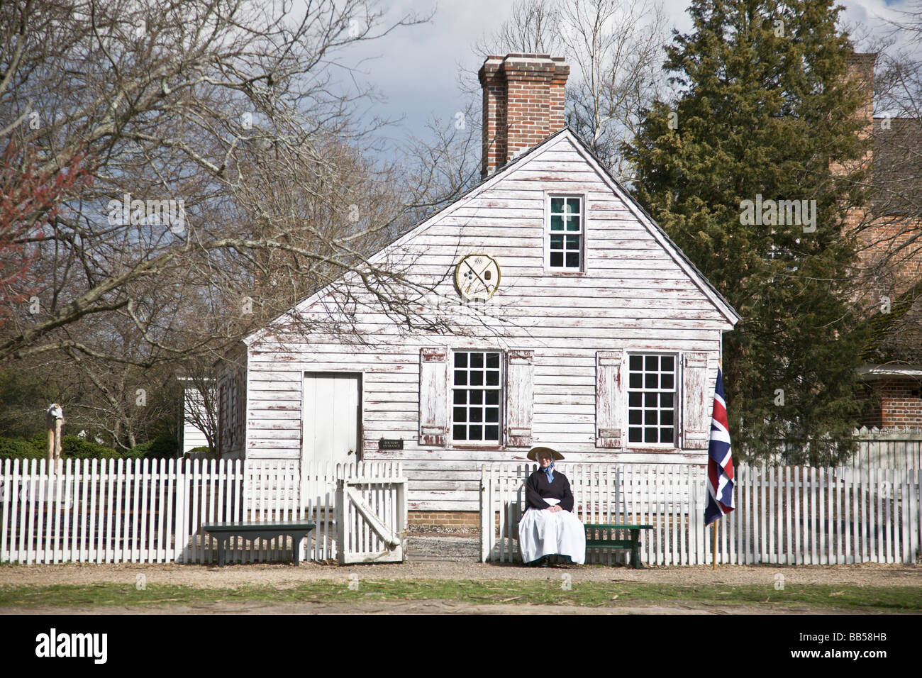 Une femme assise à l'extérieur de l'armurier à Colonial Williamsburg, Virginie. Banque D'Images