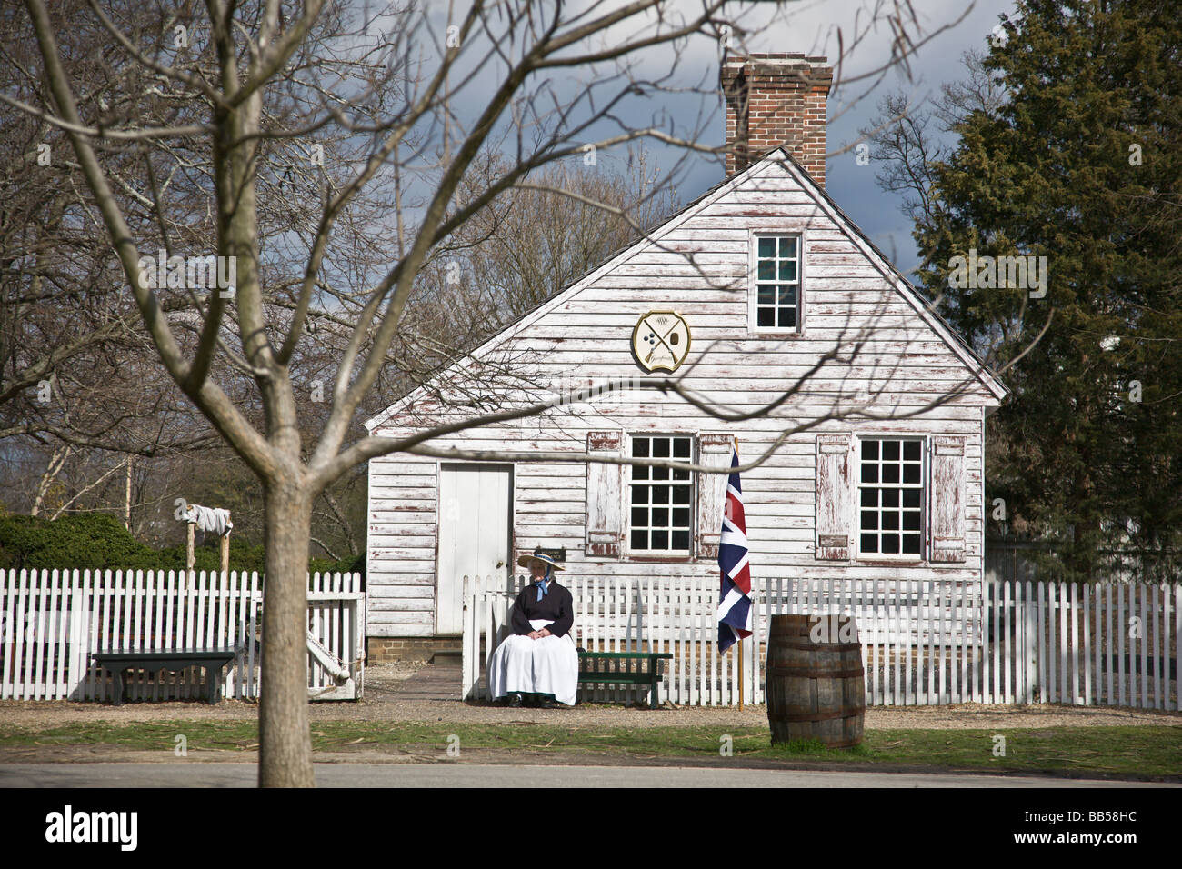 Une femme assise à l'extérieur de l'armurier à Colonial Williamsburg, Virginie. Banque D'Images