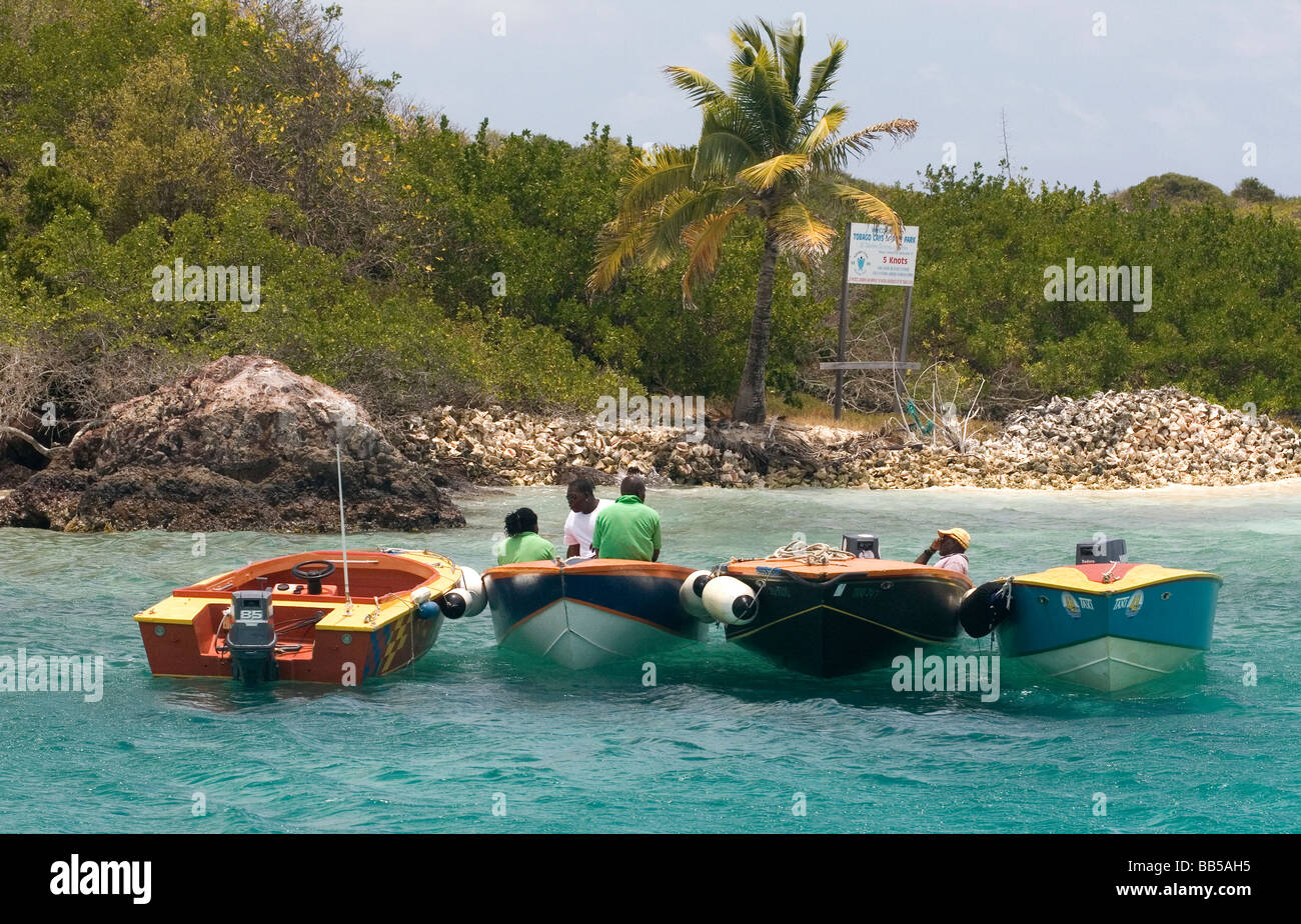 Arrêt dans les Tobago Cays - les exploitants de taxis de l'eau se détendre dans leurs bateaux sous un soleil tropical chaud sur un océan turquoise. Banque D'Images