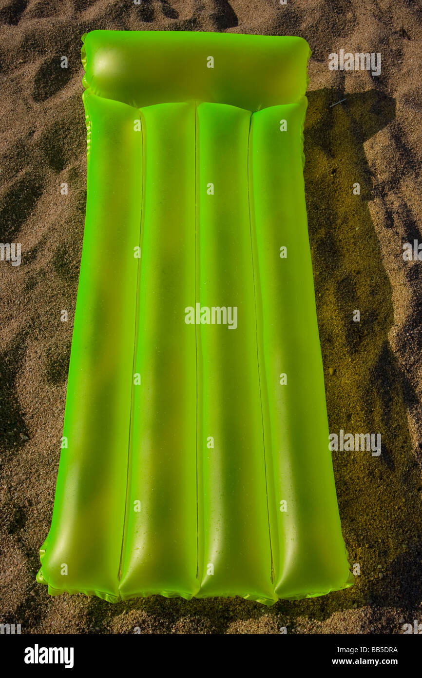 Matelas vert allongé sur un sable d'une plage de Costa Brava Espagne Banque D'Images