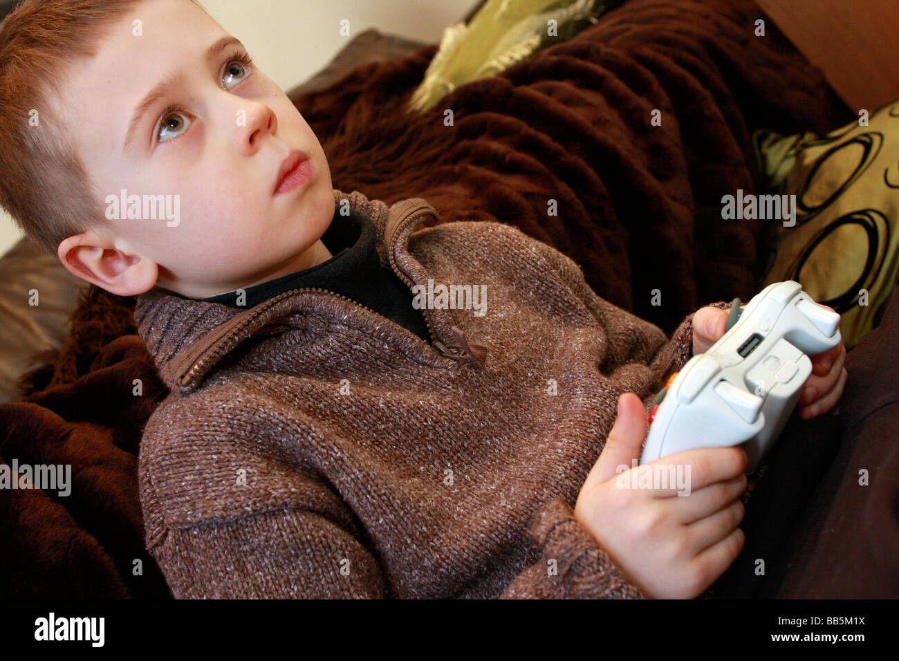 Jeune garçon jouant holding de télécommandes pour XBox 360. Banque D'Images