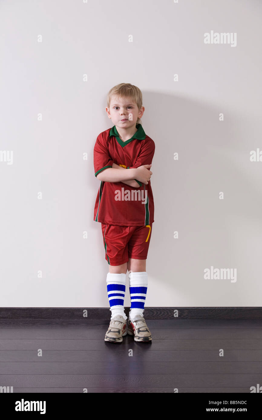 Porter des vêtements de sport garçon mur âgistes penchée Banque D'Images