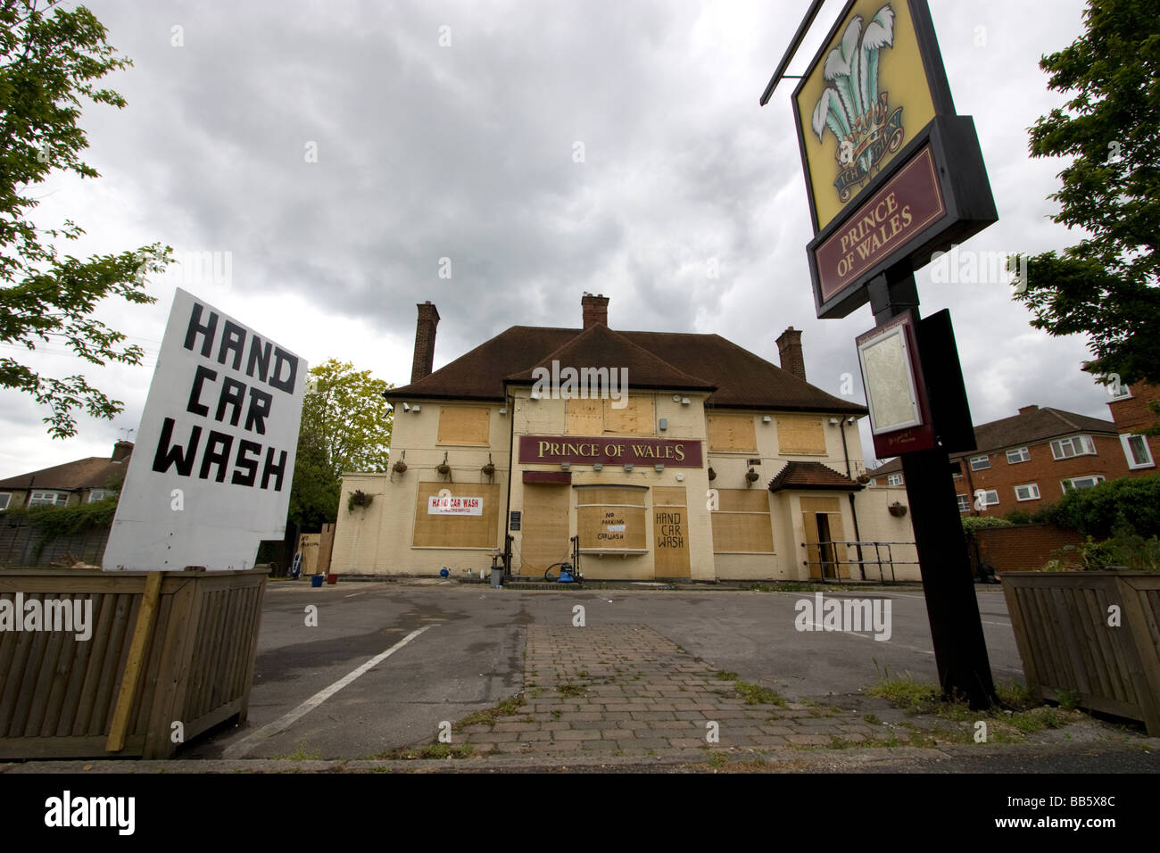 Pub fermé fermé Prince of Wales public House avec fenêtre à volets et panneaux de lavage de voiture à la main dans le parvis Chingford Londres, Royaume-Uni Banque D'Images