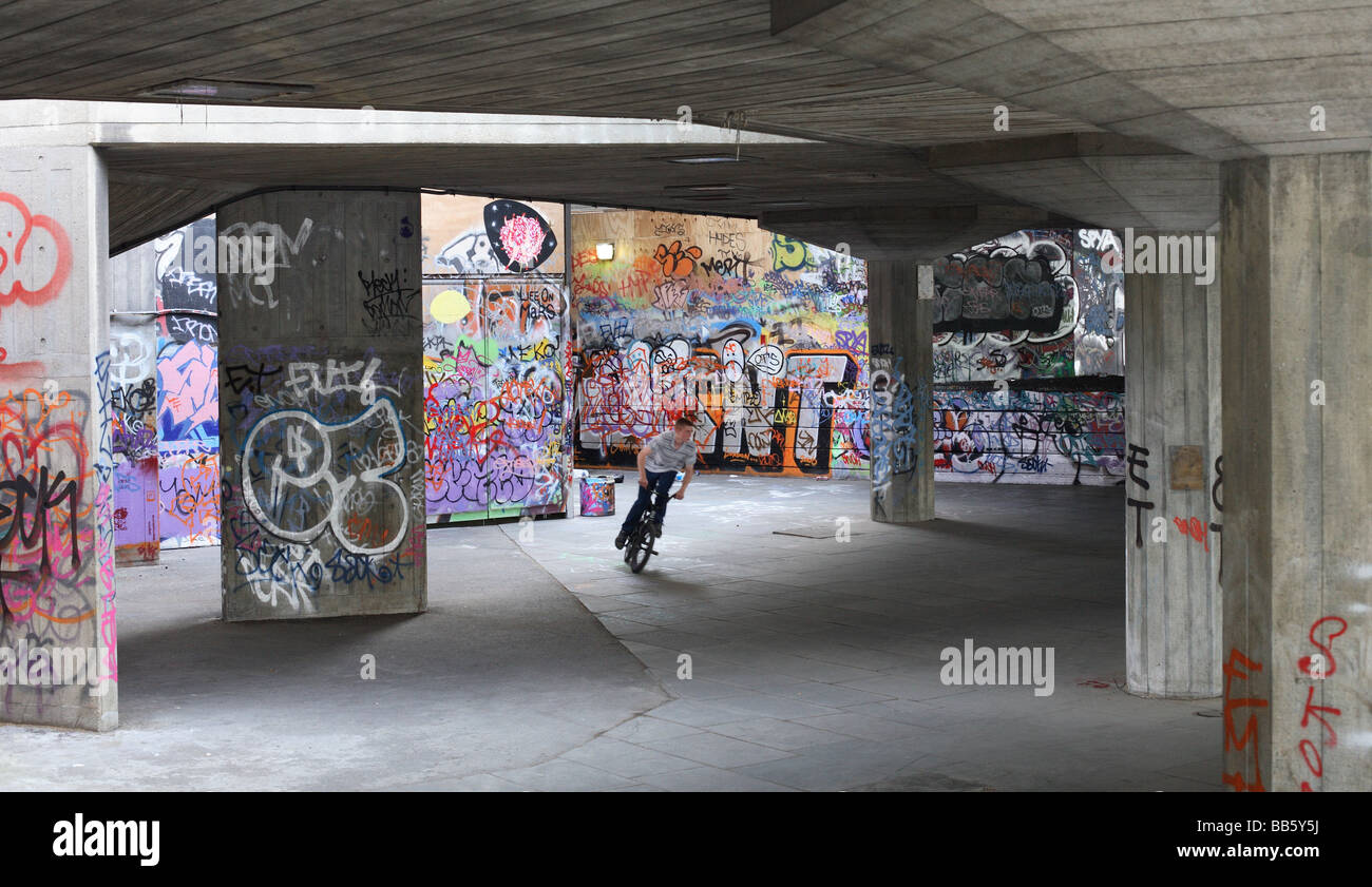 Un garçon sur son vélo BMX dans une zone graffiti skateboard à Londres Banque D'Images